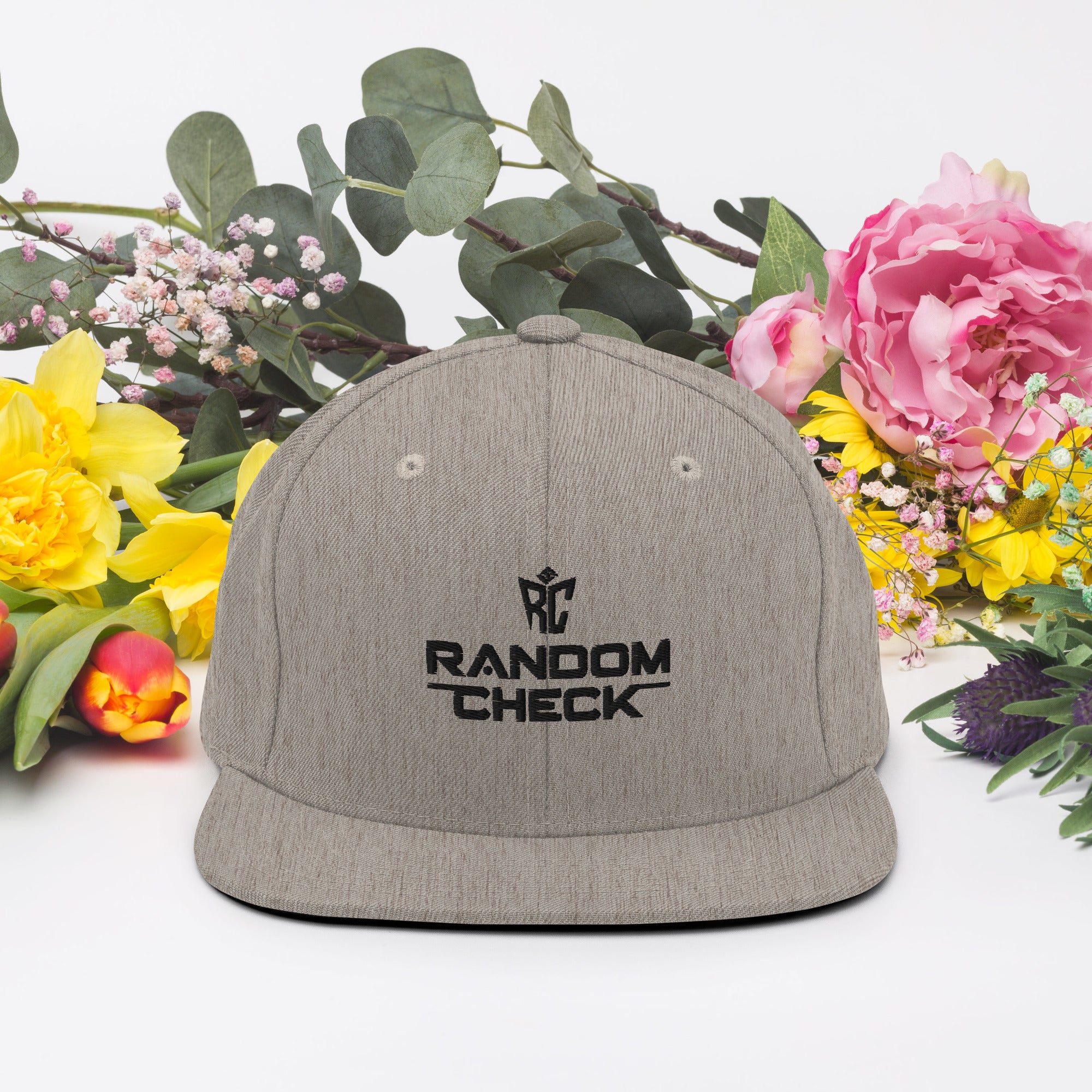 Gray cap with 'RANDOM CHECK' logo on a white background with flowers