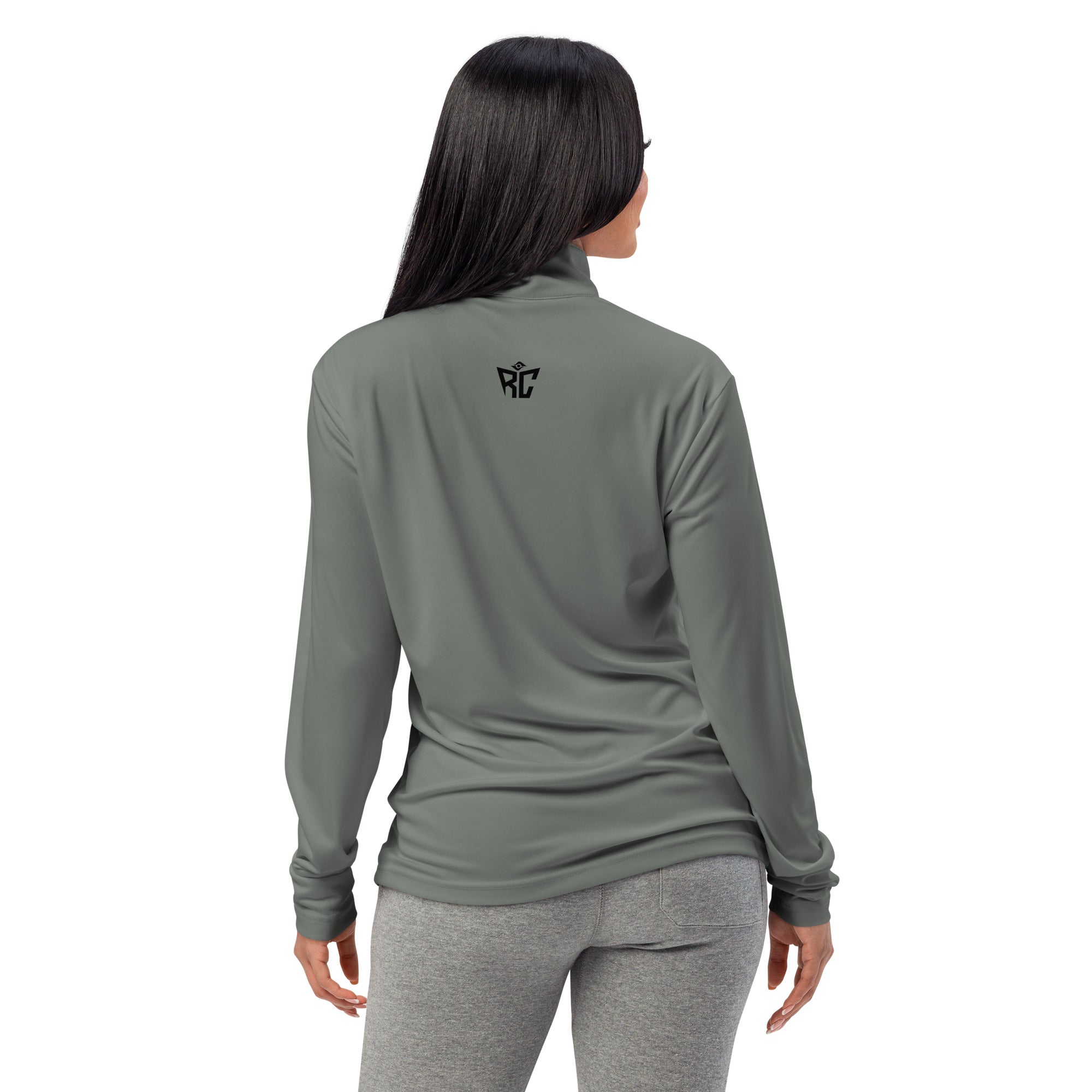 Woman wearing a green long-sleeve athletic top and gray leggings on a white background