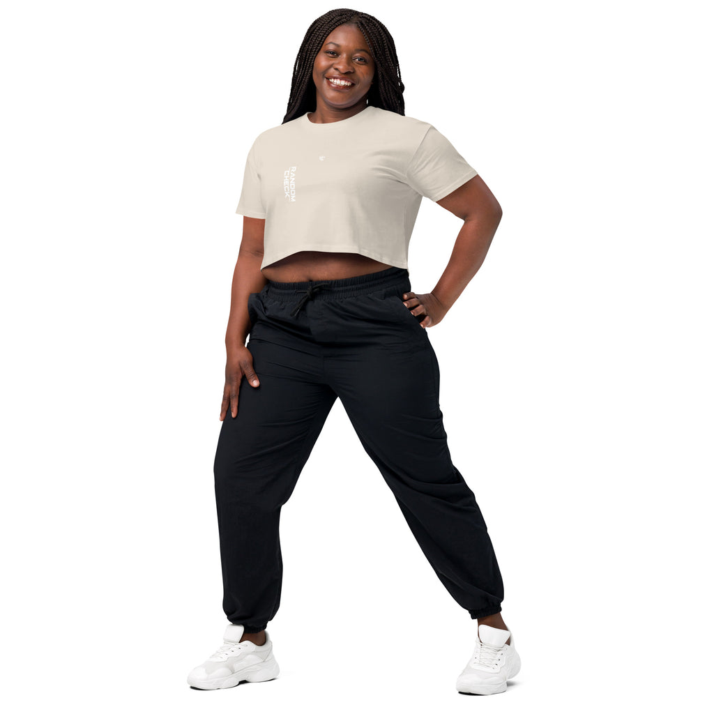 Woman wearing a beige crop top and black pants on a white background