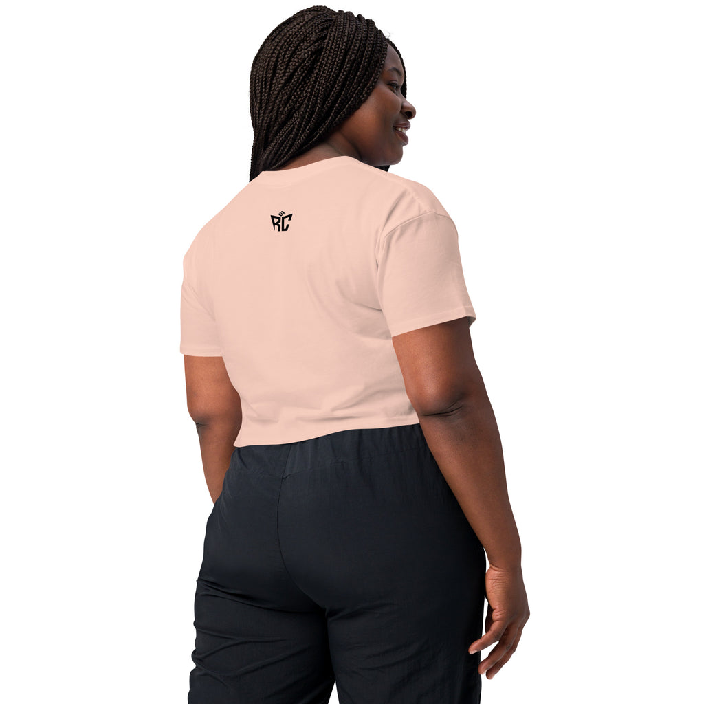 Woman wearing a light pink t-shirt with a logo on the back, standing against a white background